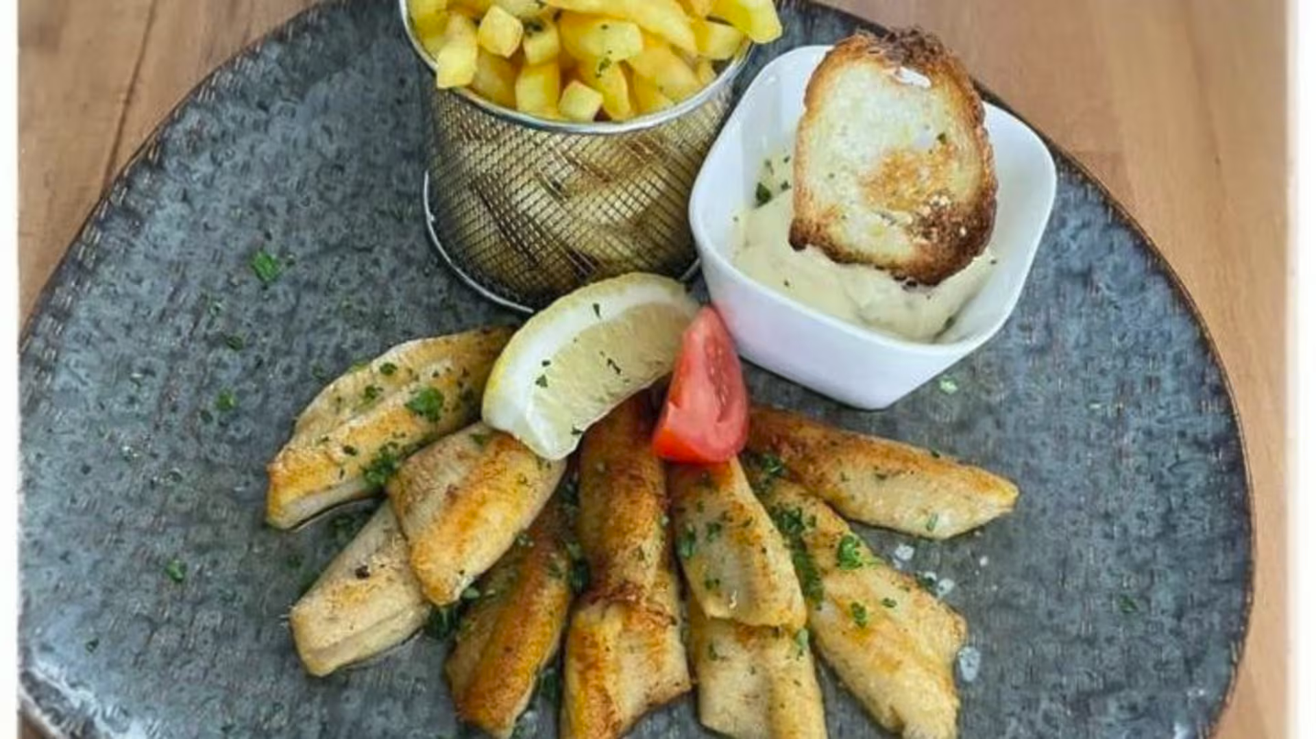 Plat de poisson servi avec pommes sautées et sauce